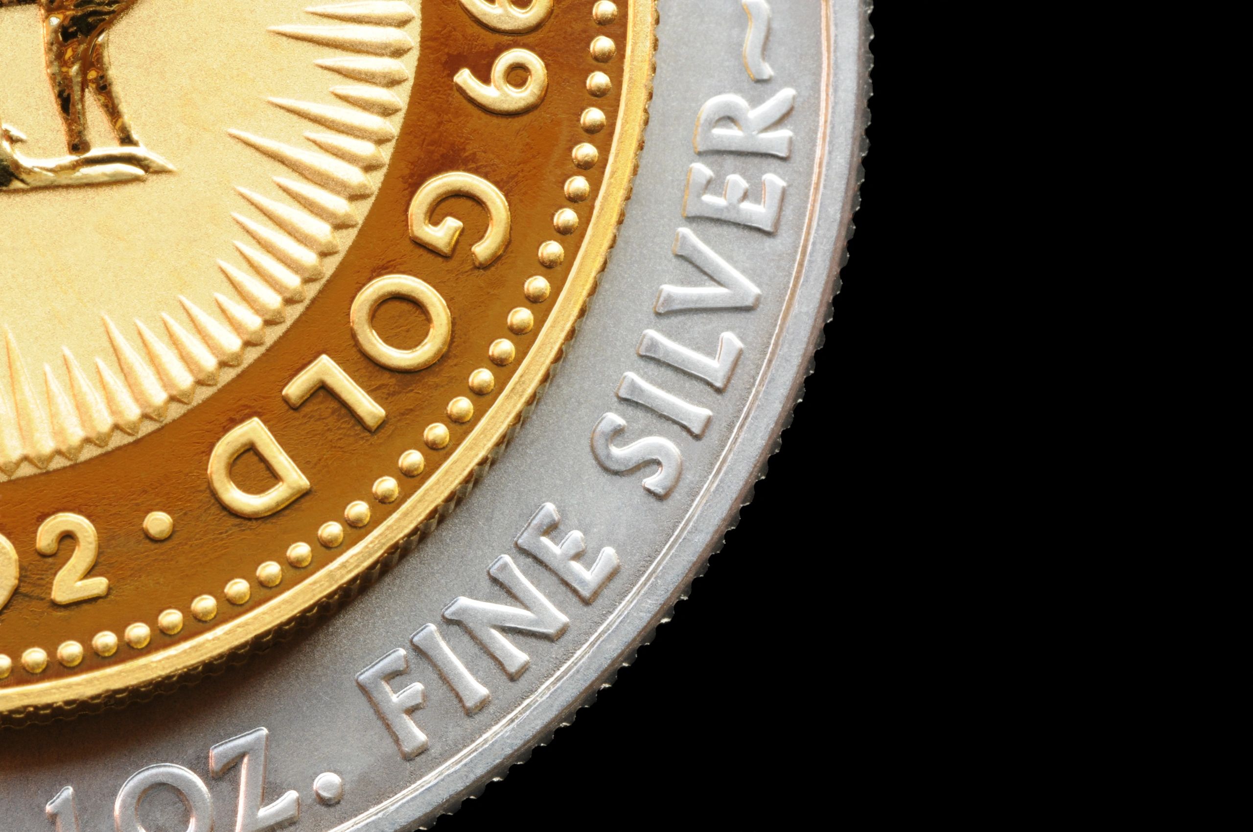 Close-up of gold and silver coin details on a dark background